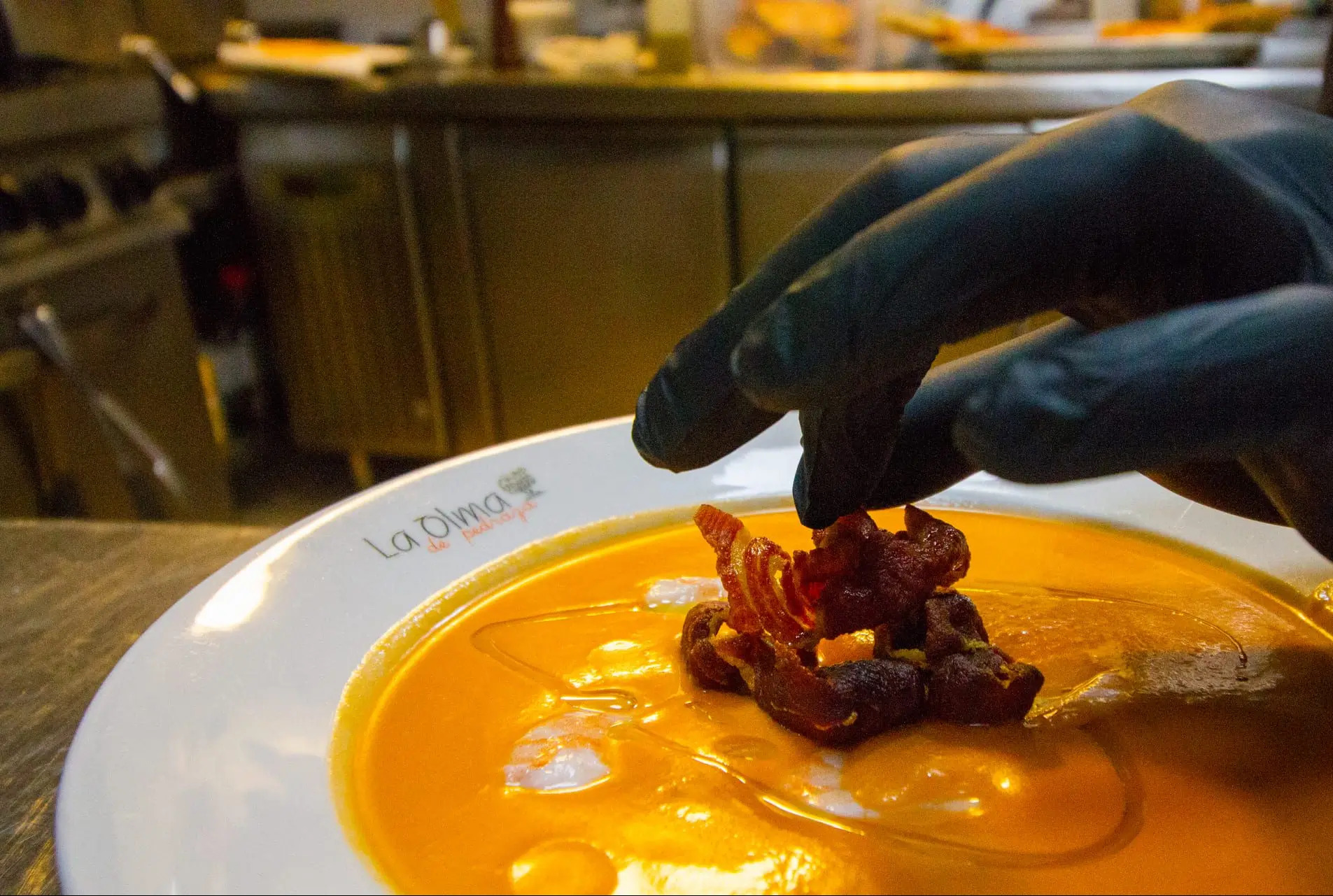 Decoración final de un salmorejo en la cocina de La Olma de Pedraza